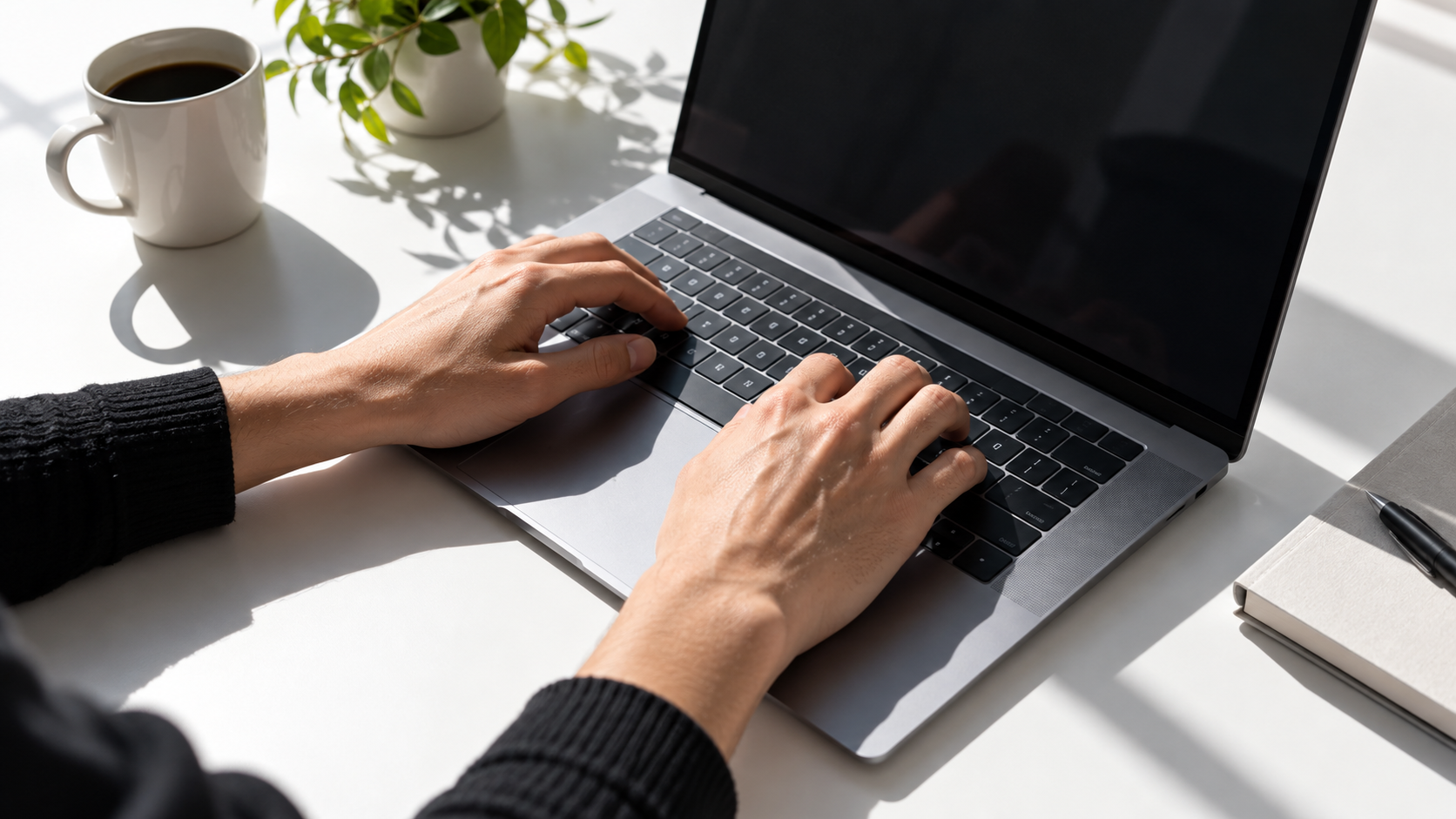 Hands typing on a laptop